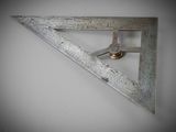 a picture of a metal triangle with a clock on it