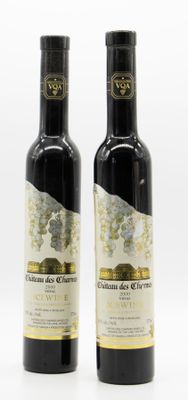 two bottles of olive oil sitting next to each other on a white surface