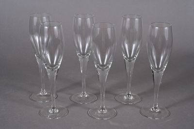 four empty wine glasses are lined up on a gray surface