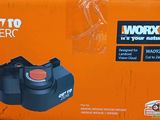 an orange box with a black handle and a red button on it