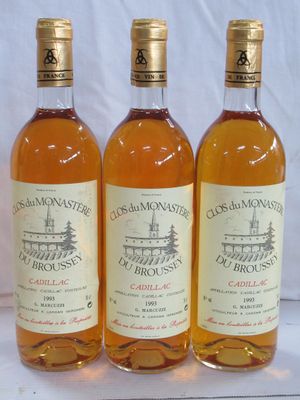 trois bouteilles de vin sont alignées sur une surface blanche