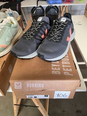 two pairs of running shoes sitting on top of a box on a table