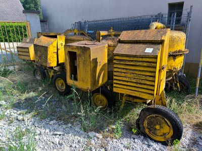 une grosse machine jaune qui est garée dans l'herbe