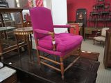 une chaise rose qui se trouve dans une pièce