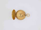 a close up of a gold pocket watch on a white surface