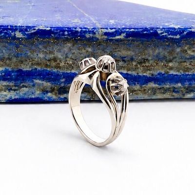 Gros plan sur une bague en argent ornée d'une fleur