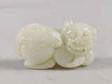 une image représentant une figurine blanche en forme de chat posée sur une surface blanche