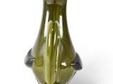 a green vase with a black handle sitting on a white surface