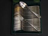 a lot of silver spoons and spoons in a box