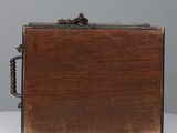 an old wooden box with a metal handle on a table
