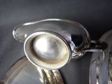 a silver teapot with a pearl in it on a silver plate