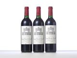three bottles of red wine sitting on top of a table