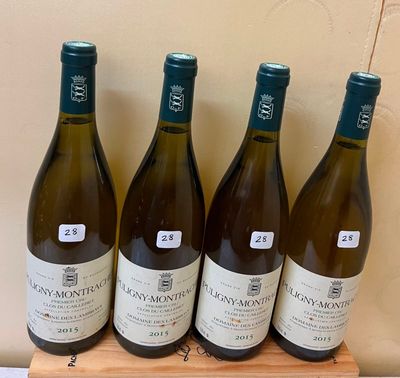 four bottles of wine are lined up on a wooden stand