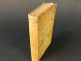 an old book sitting on top of a table next to a black background