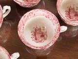 six red and white coffee cups sitting on top of a wooden table