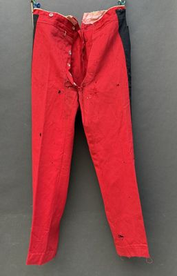 un pantalon rouge suspendu à une corde à linge