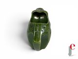 a green ceramic shoe that is sitting on a white surface