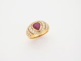 a gold ring with a ruby stone and diamonds on a white background