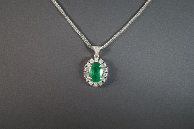 un pendentif en émeraude et diamant sur une chaîne en argent