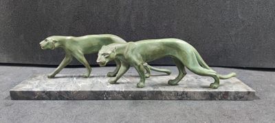 two statues of a dog and a cat on a marble base