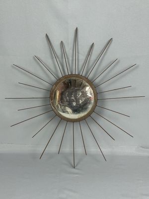 un soleil rayonnant en métal accroché au mur