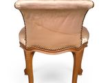 the back of a chair with a leather seat and wooden legs