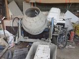 une bétonnière posée au milieu d'un tas de ferraille