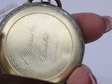 a close up of a person holding a pocket watch