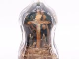 a glass bottle with a picture of a man on a cross inside of it