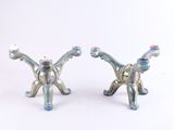 deux figurines de chats en argent posées sur un fond blanc