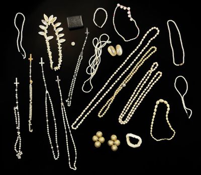 a group of various necklaces and bracelets on a black surface