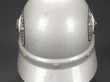 an old white helmet on a black surface with a black background