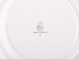 an image of a white plate with a gold emblem on it