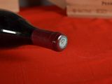 a bottle of wine sitting on a red table cloth