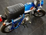 a small blue and white motorcycle on display at a show