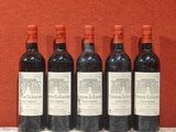 six bouteilles de vin rouge alignées sur une table devant un mur rouge