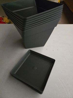 une pile de plateaux carrés noirs posés sur une table