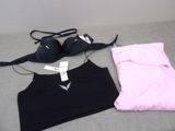 un haut de soutien-gorge noir et un haut de soutien-gorge rose posés sur un lit