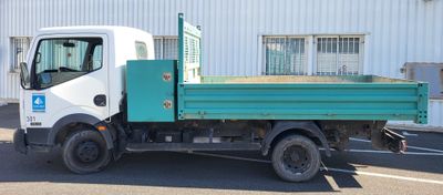un camion vert et blanc garé devant un immeuble
