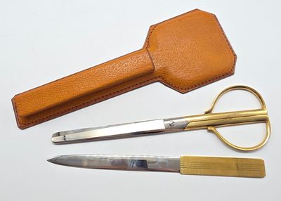 une paire de ciseaux et un étui en cuir posés sur la table