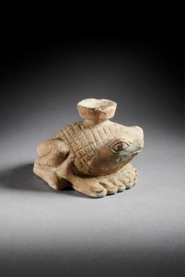 an ancient figurine of a turtle with a hat on its head