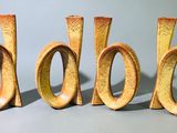 trois lettres en bois posées sur une table