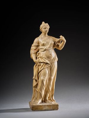 une statue sculptée représentant une femme tenant un oiseau