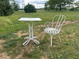 a white table and two chairs in a field