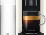 a white coffee maker next to a glass of water