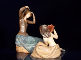 a figurine of a man and a woman sitting on a rock