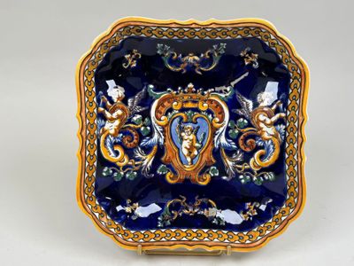 une assiette bleue et dorée sur laquelle est représentée une femme