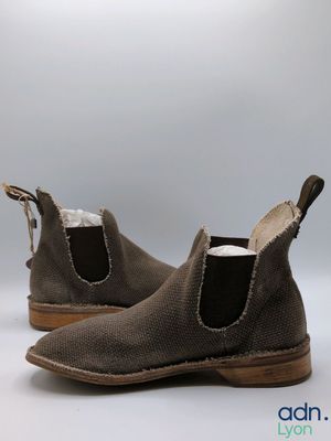 grey sued ankle boots with brown soles on a white background