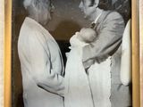 an old photo of a man holding a baby in his arms
