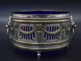 a silver and blue glass bowl on a black surface